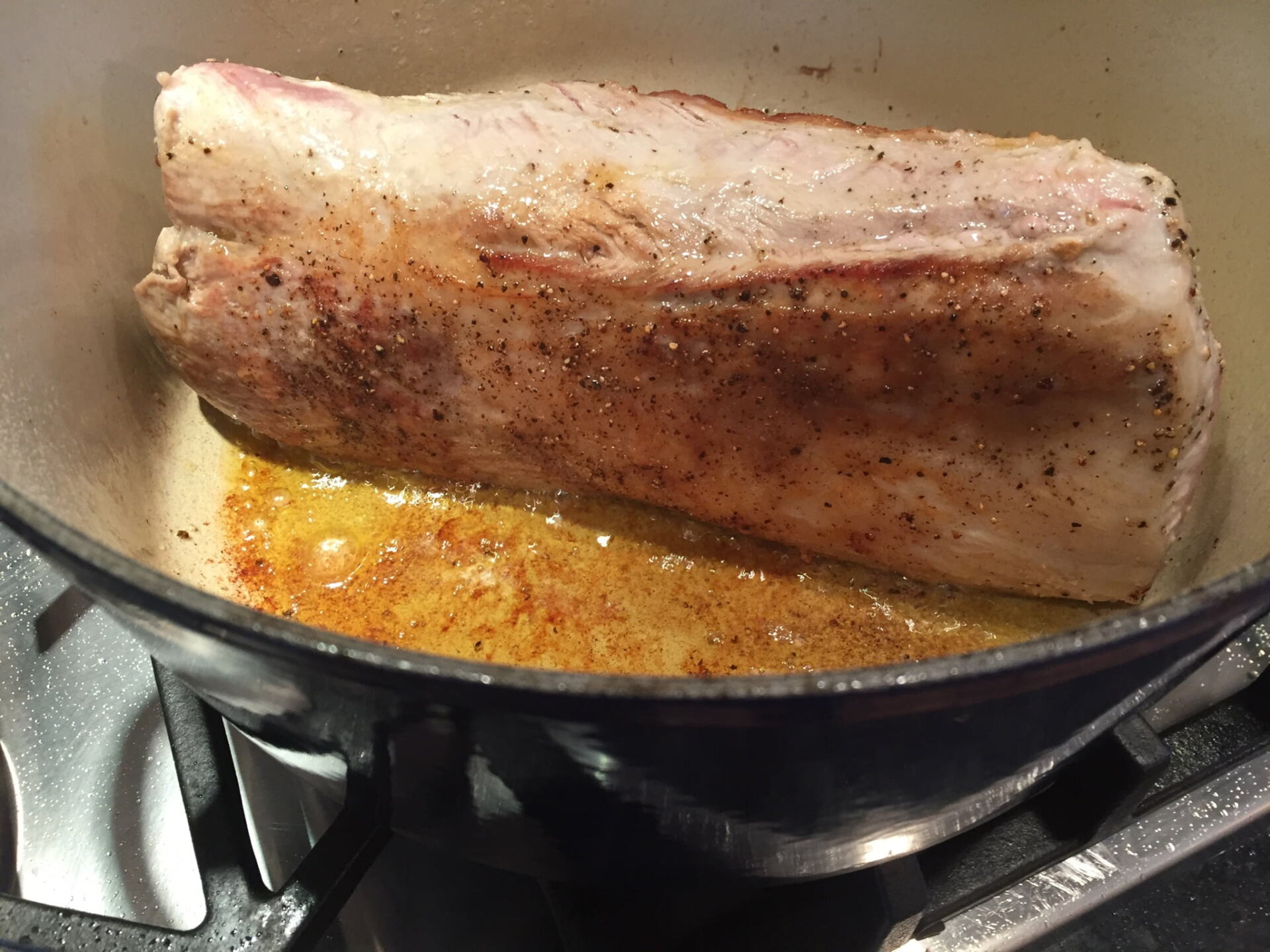 Pork roast browning in a pan